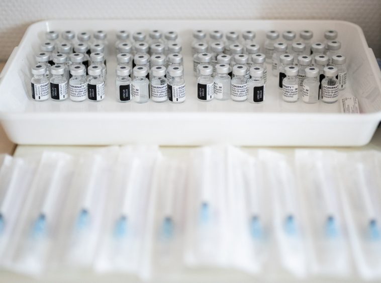 Vakcinával teli ampullák és oltásra előkészített fecskendők