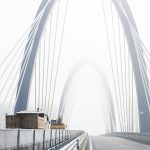 Munkagépek haladnak át angolosan az M44-es új Tisza-hídján 2021. december 15-én