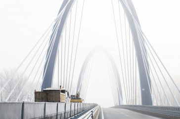 Munkagépek haladnak át angolosan az M44-es új Tisza-hídján 2021. december 15-én