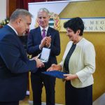 Csasztvanné Vass Edit átveszi a díjat Zalai Mihálytól, a megyei közgyűlés elnökétől. A háttérben Soltész Miklós, a Miniszterelnökség egyházi és nemzetiségi kapcsolatokért felelős államtitkára.