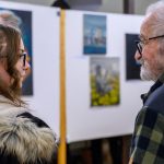 Mihály Martina és Lóránt János Demeter. A háttérben a fiatal festő alkotásai.