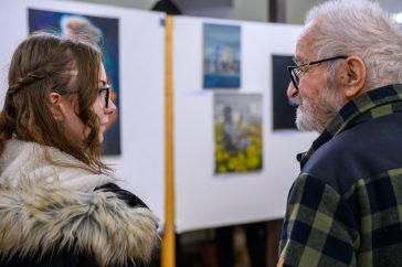Mihály Martina és Lóránt János Demeter. A háttérben a fiatal festő alkotásai.