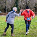 A 89 éves Fehér Károllyal pacsizik Rohonyné Urbancsok Zsuzsanna a Hóbogyó futam résztávjának teljesítésekor 2024. december 15-én.