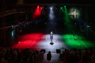 A Szent Mihály-napi tűzgyújtás kultúrprogramjában fellépő Csonka Dóra mögött a Napkorongos Csodaszarvas látható.