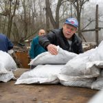 Molnár József polgármester segít a barnakőszén lepakolásában 2025. november 14-én.